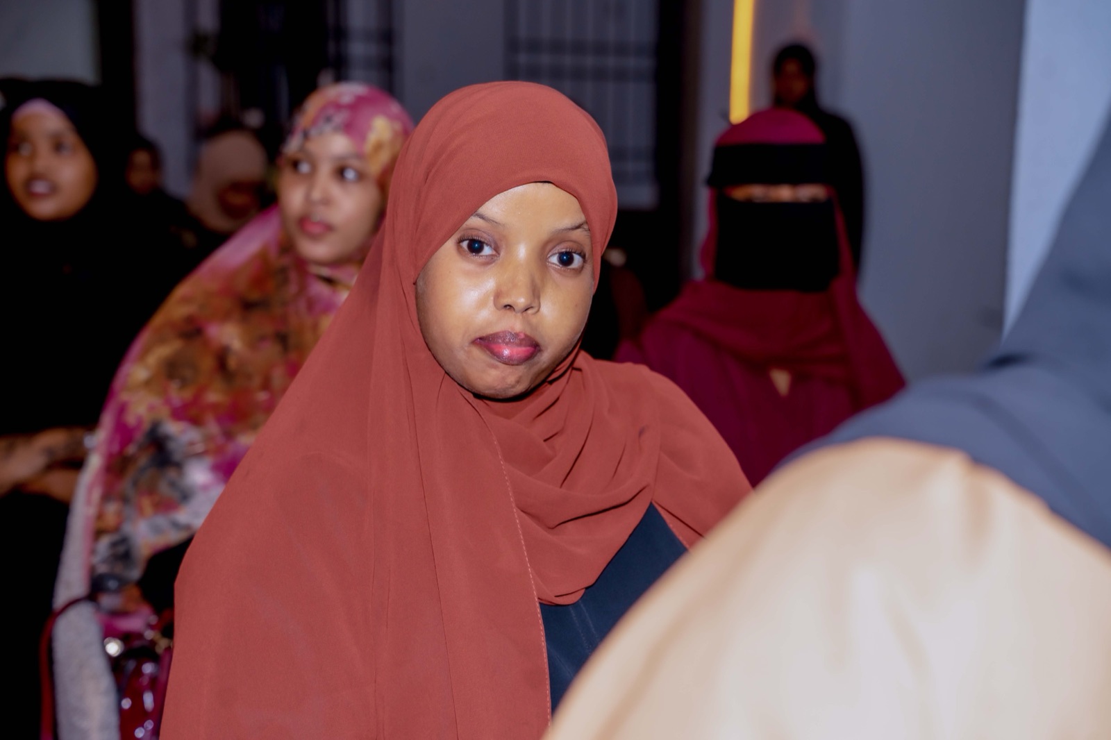 A guest in an orange hijab at the Pre-Event