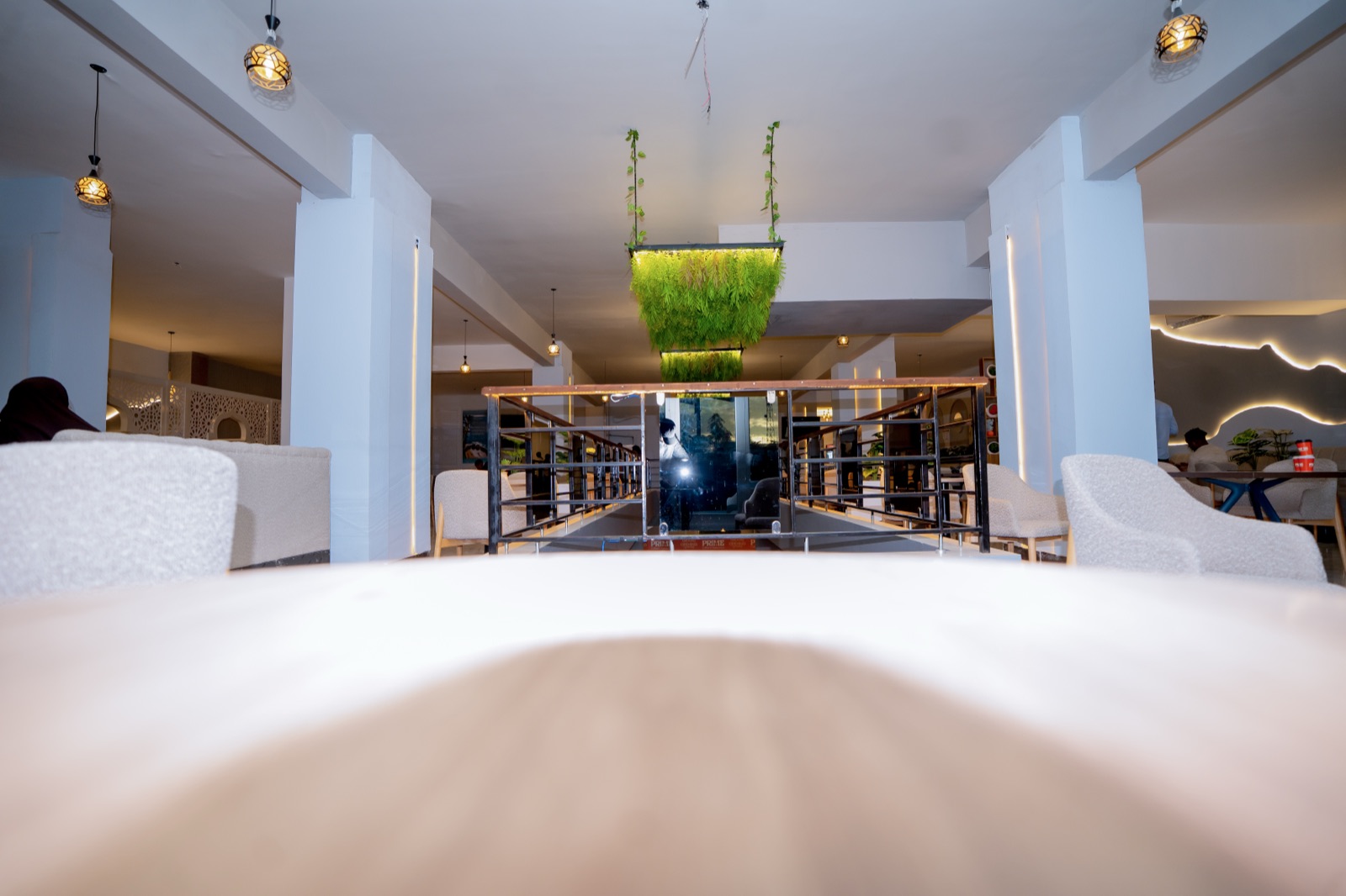The Prime dining room with pendant lights and a hanging green planter